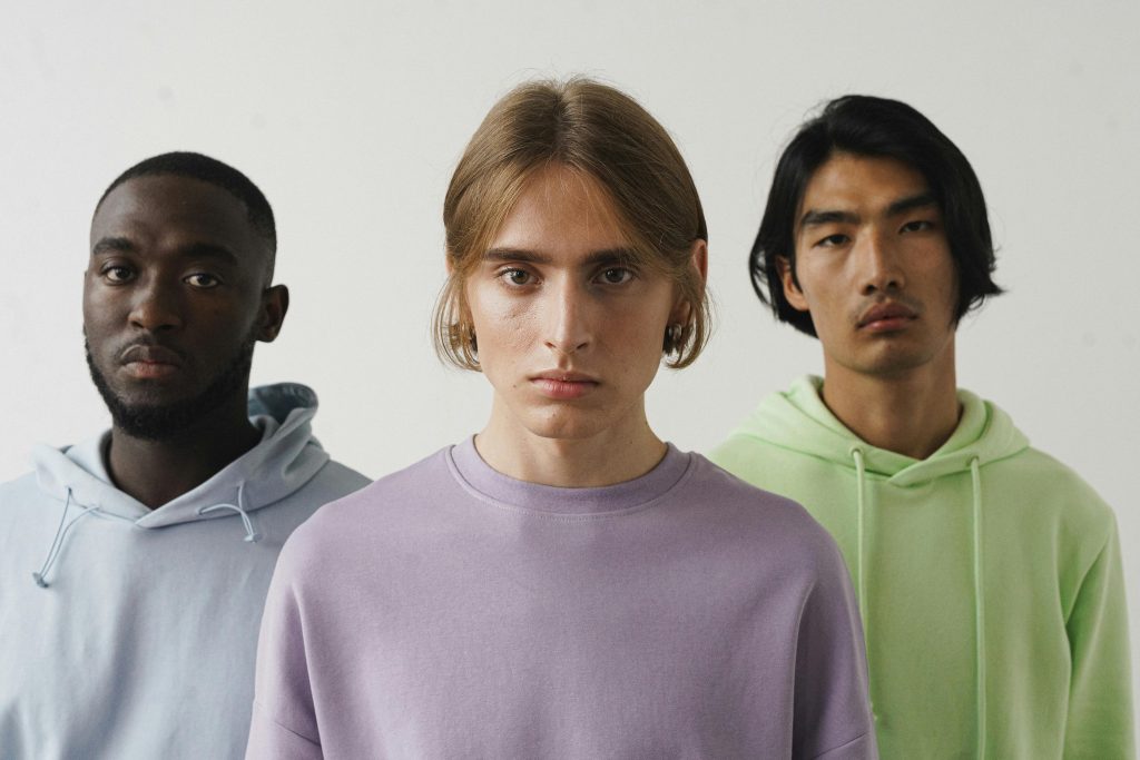 Primer plano sujetos pastel Primer plano de tres sujetos con sudaderas en tono pastel.